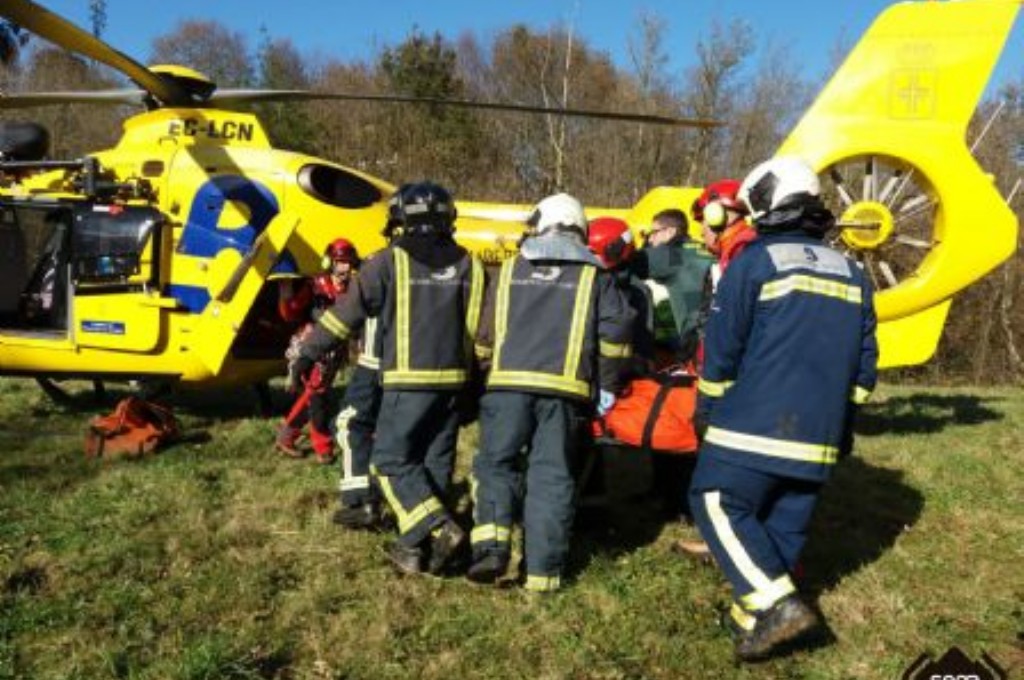Bomberos en el accidente ferroviario de Llanes trasladando a un herido al helicptero medicalizado.